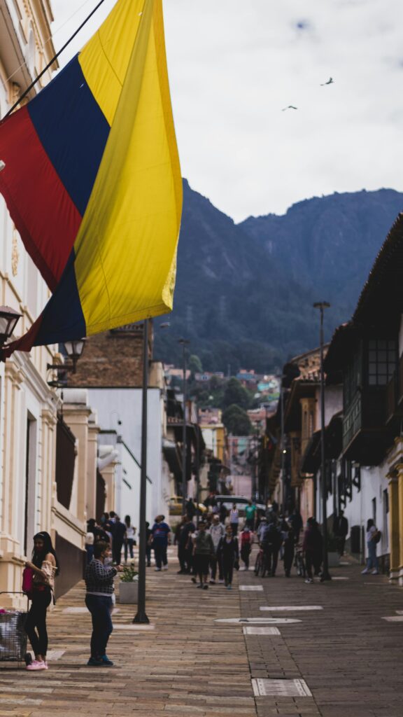 pexels photo 10762961 10762961 Vibrant Colombian flag flutters above a bustling street in Bogotá, capturing urban life.